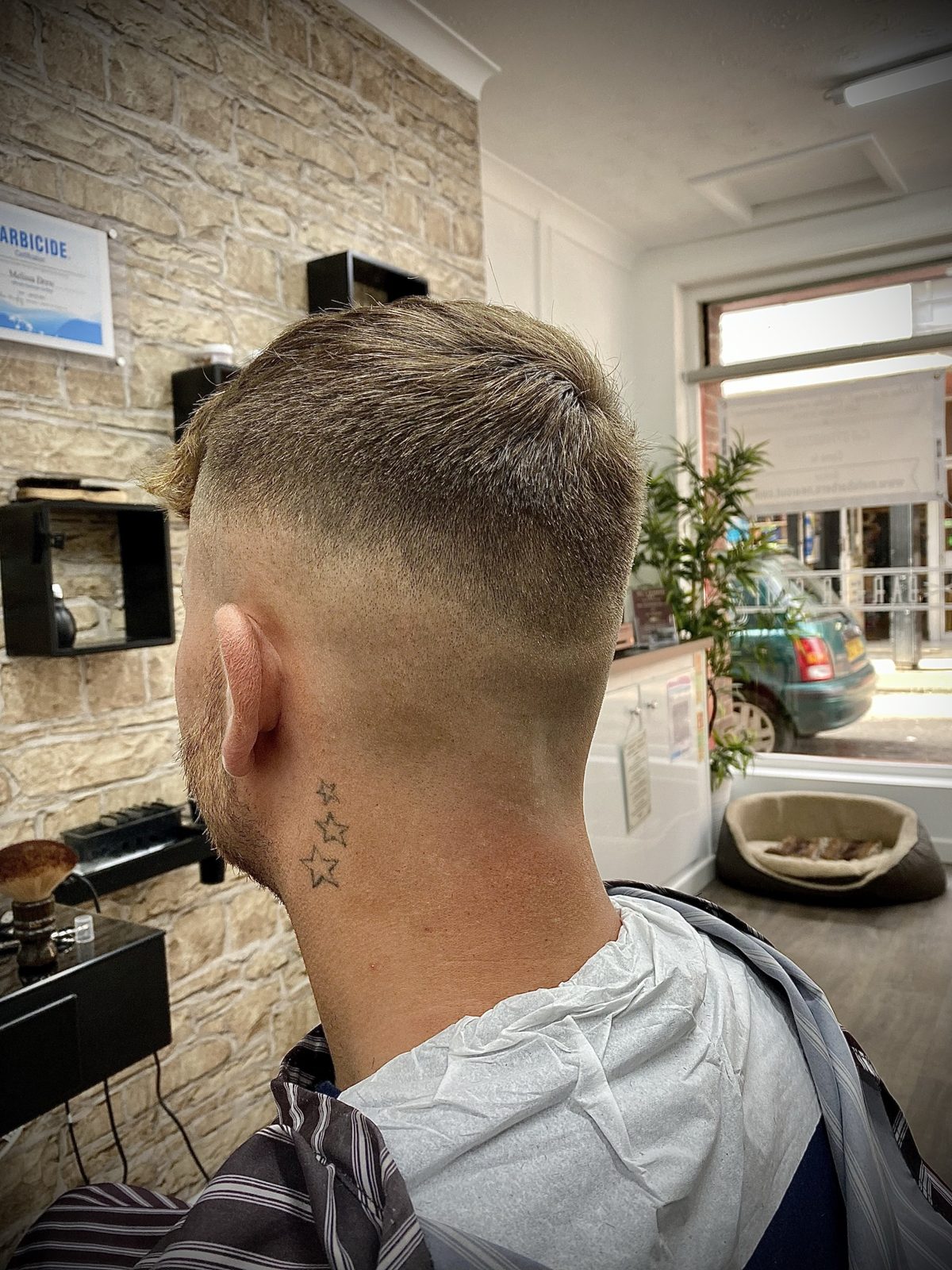 A skin fade from the back, star tattoo on the neck