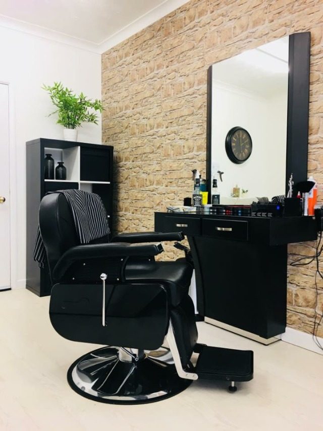 A barber chair and station against the stone-effect wall