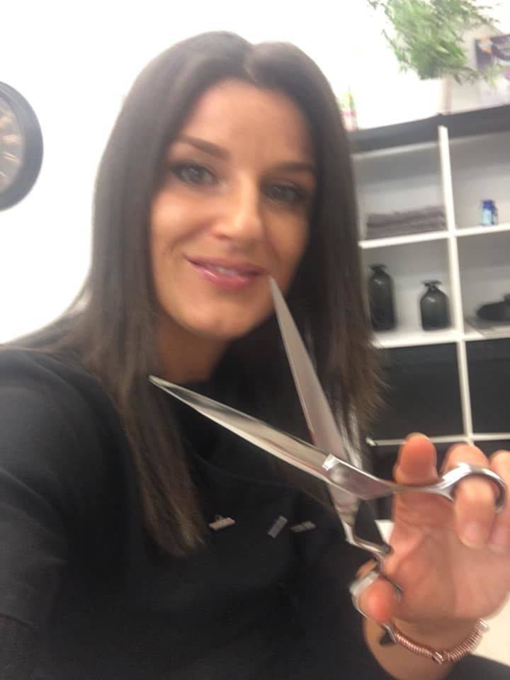 Mel holding her scissors in the shop