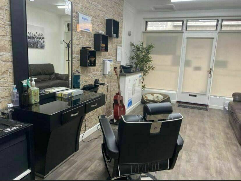 The shop interior with the barber chair, mirrors and sofa