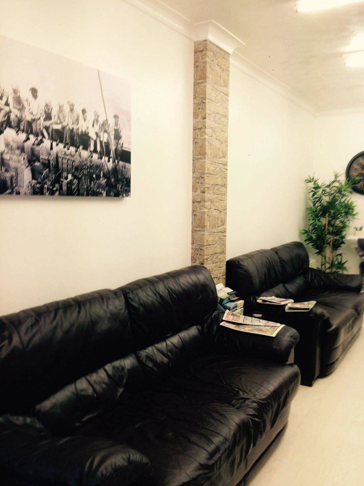 Black leather waiting sofas under a framed print